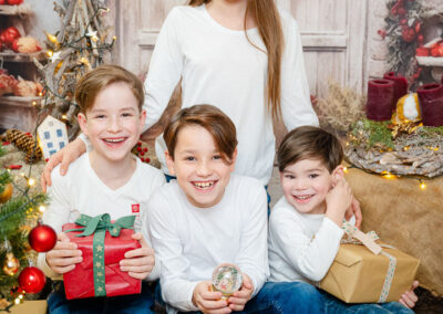 Ein Familienfoto. Drei Jungs und ein größeres Mädchen mit weissen Oberteilen und blue jeans