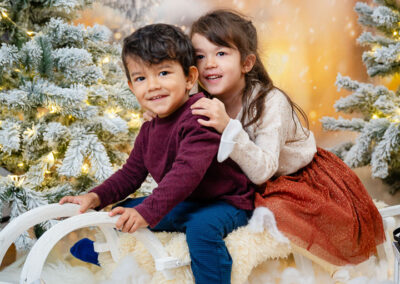Ein Junge und ein Mädchen fahren Schlitten im Fotostudio