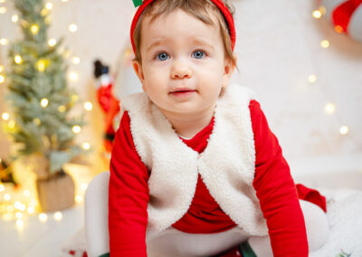 Kleines Mädchen vor buntem Weihnachtshintergrund